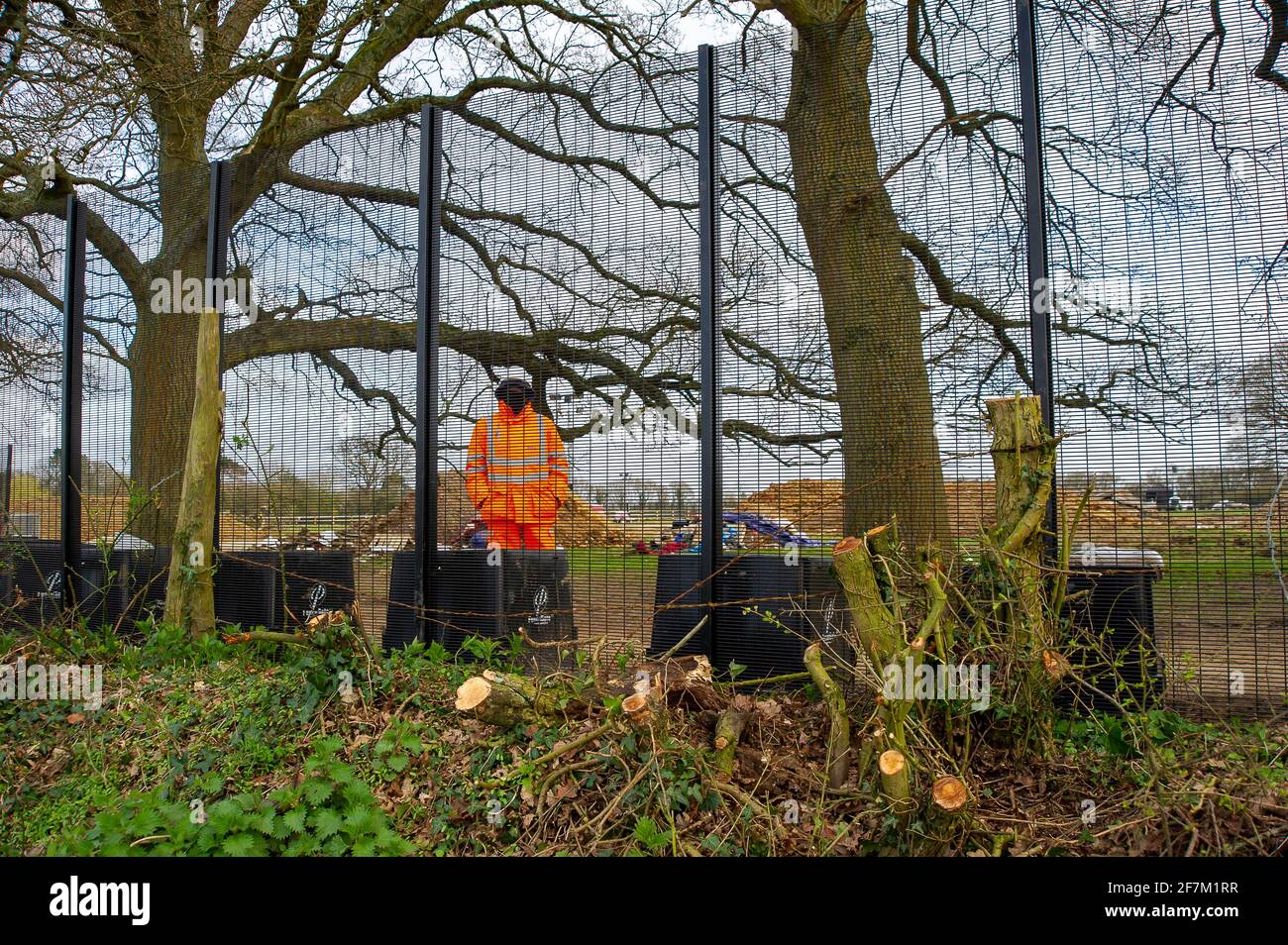 Great Missenden, UK. 3rd April, 2021. HS2 have put high security fencing in the fields next to houses near to the historical sunken holloway of Leather Lane. HS2 have destroyed a number of iconic and much loved oak trees as well as ancient hedgerows along Leather Lane. HS2 will be felling more oaks off Leather Lane too. HS2 Security are in the fields next to the oaks 24/7 and intimidating local residents and members of the public. The High Speed 2 rail link from London to Birmingham is carving a huge ugly scar across the Chilterns which is an AONB. Credit: Maureen McLean/Alamy Stock Photo