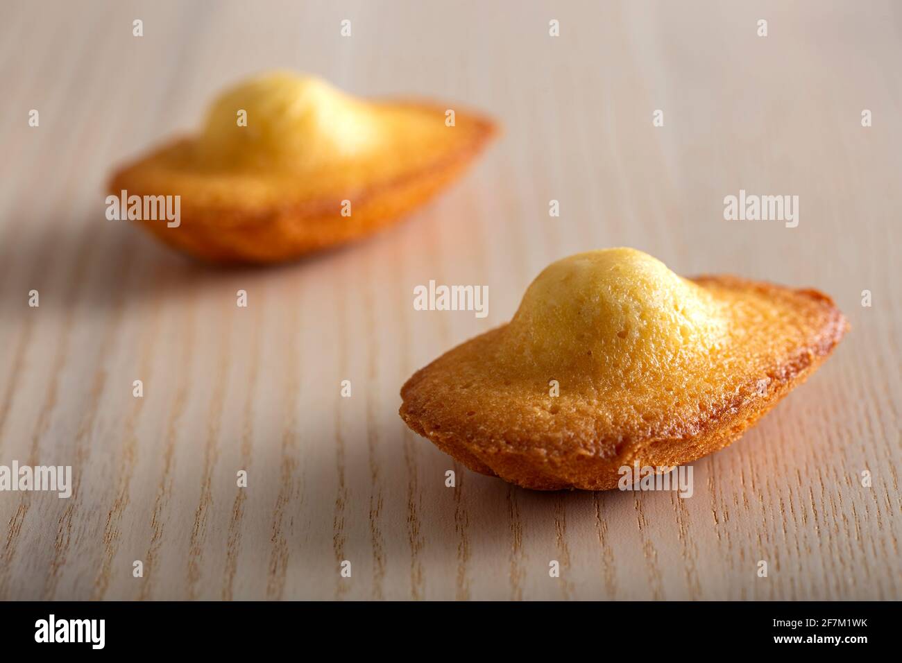Two french madeleine over a wood table Stock Photo