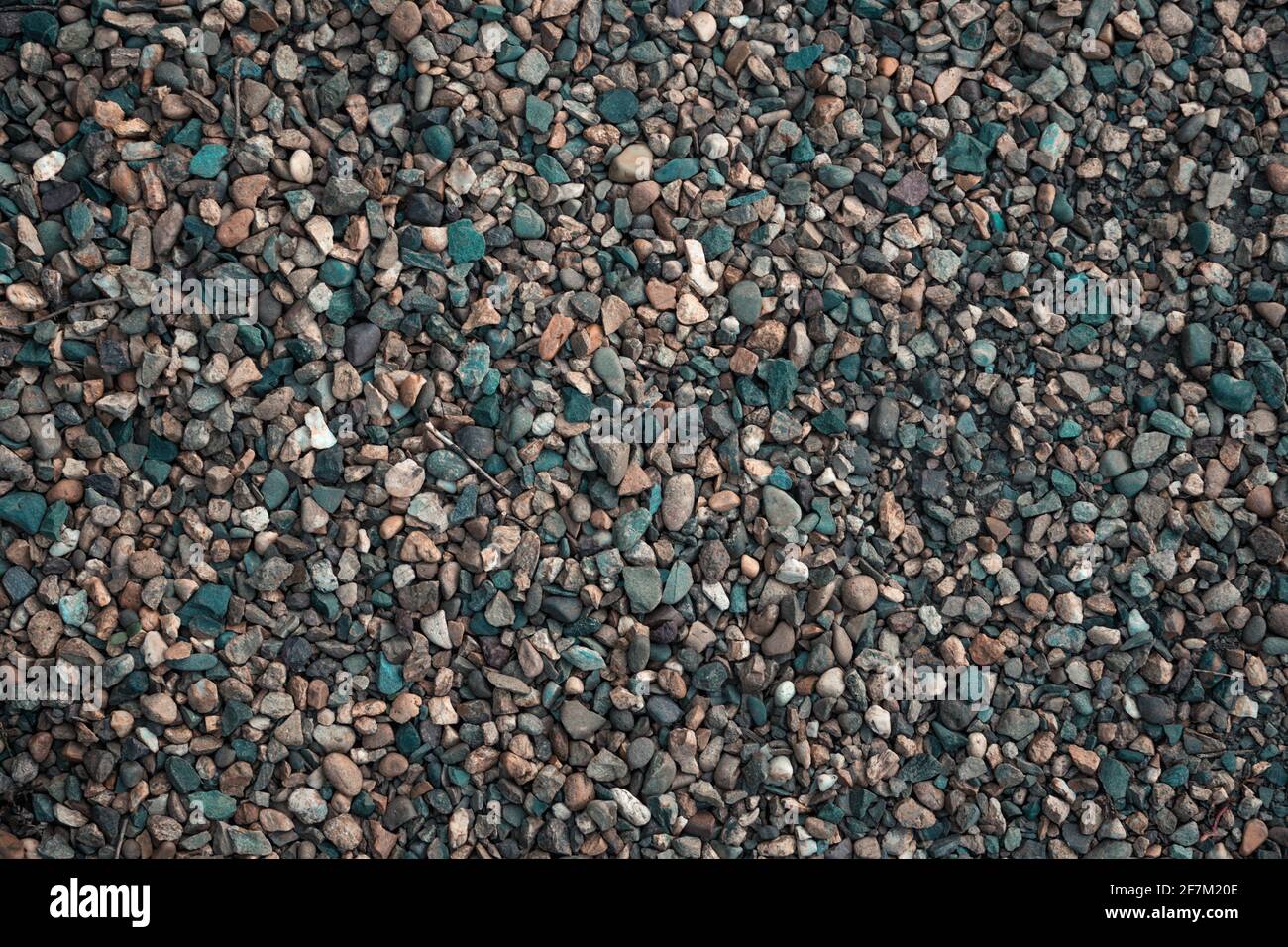 Gravel texture. Small stones, little rocks, pebbles in many shades of grey, white, brown, yellow colour. Background of small stones in oval shape. Tex Stock Photo