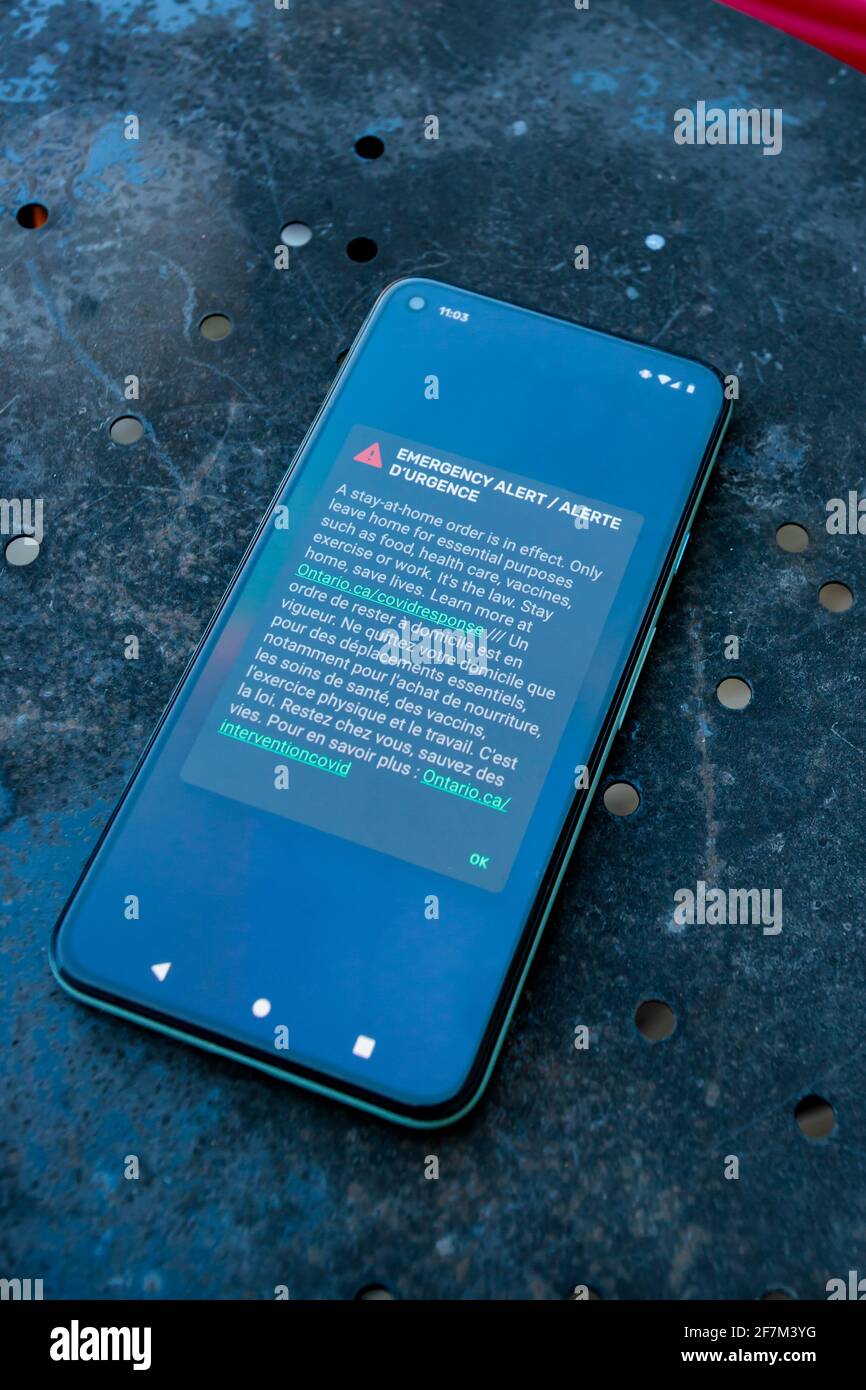 Ottawa, Ontario, Canada - April 8, 2021: A smartphone screen displays an emergency alert notifying Ontario residents of a stay-at-home order in effect Stock Photo