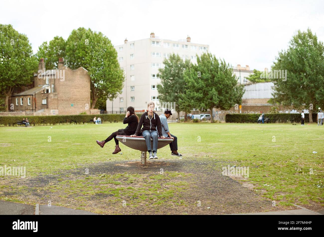 English teenagers hanging out around Brick Lane. A tight-knit circle of friends concept. Allen Gardens, East London, UK. Jul 2015 Stock Photo