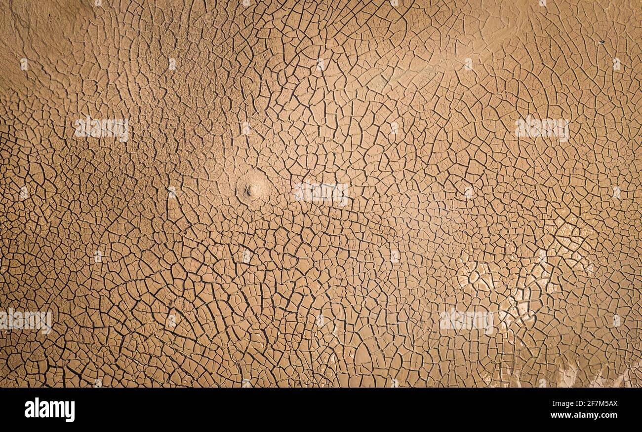 Dried lake bottom surface texture. Aerial shot of dried clay with cracks, flat view directly above Stock Photo