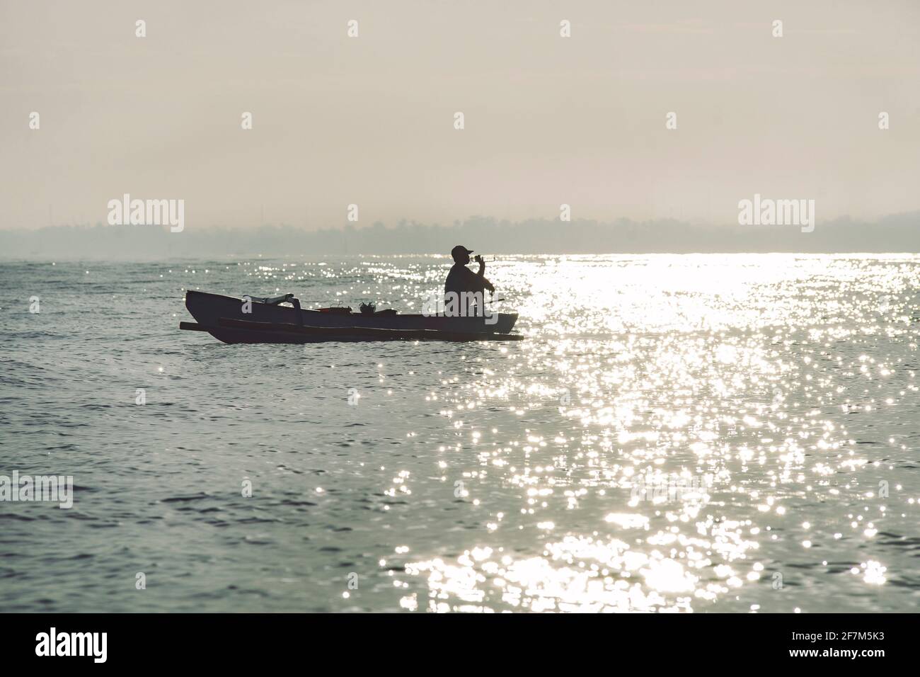 A fisherman on his boat drinks water off Buleleng in North Bali on July 20, 2019. Un pêcheur sur son bateau boit de l’eau au large de Buleleng dans le Stock Photo