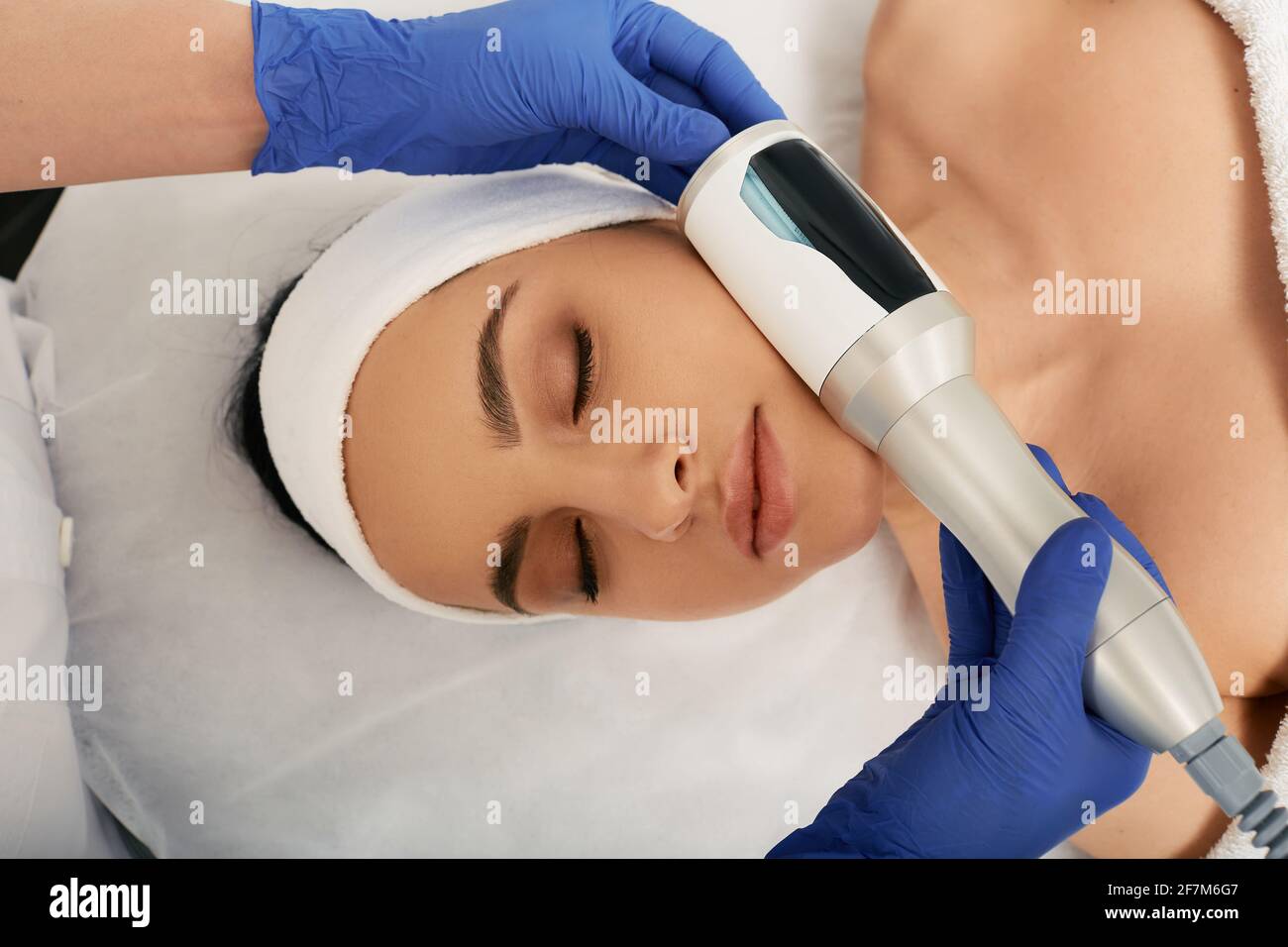 Cropped woman's face during facial endospheres therapy for correction oval face with a cosmetologist Stock Photo