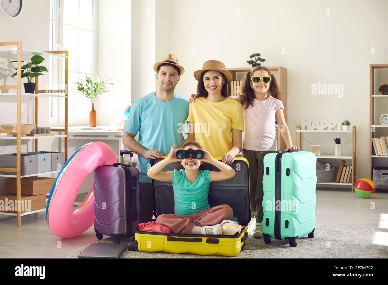 Portrait of happy young family with suitcases ready to go on summer holiday trip Stock Photo