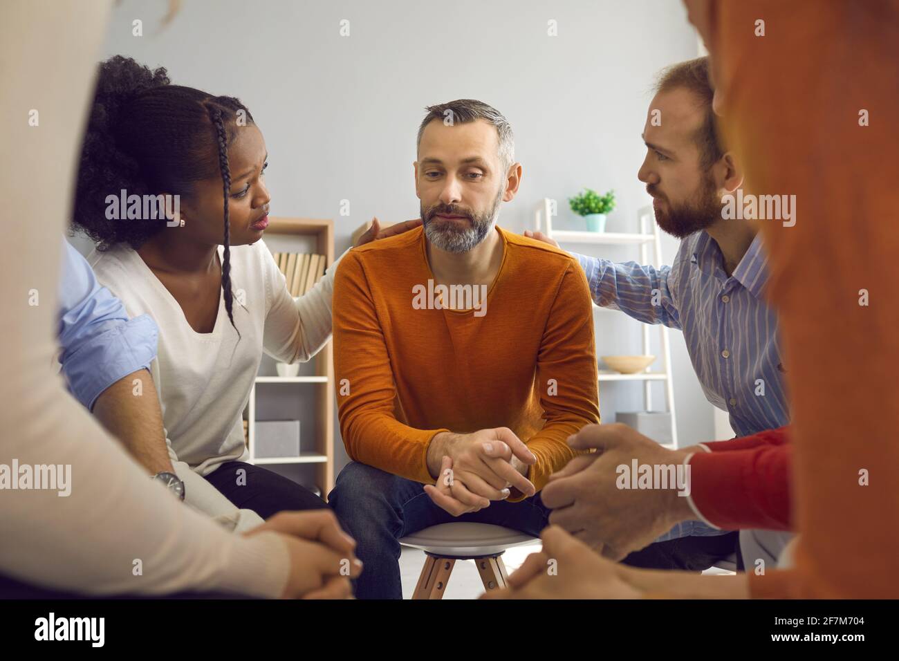 Multiracial people talking and supporting sad mature man in group therapy session Stock Photo