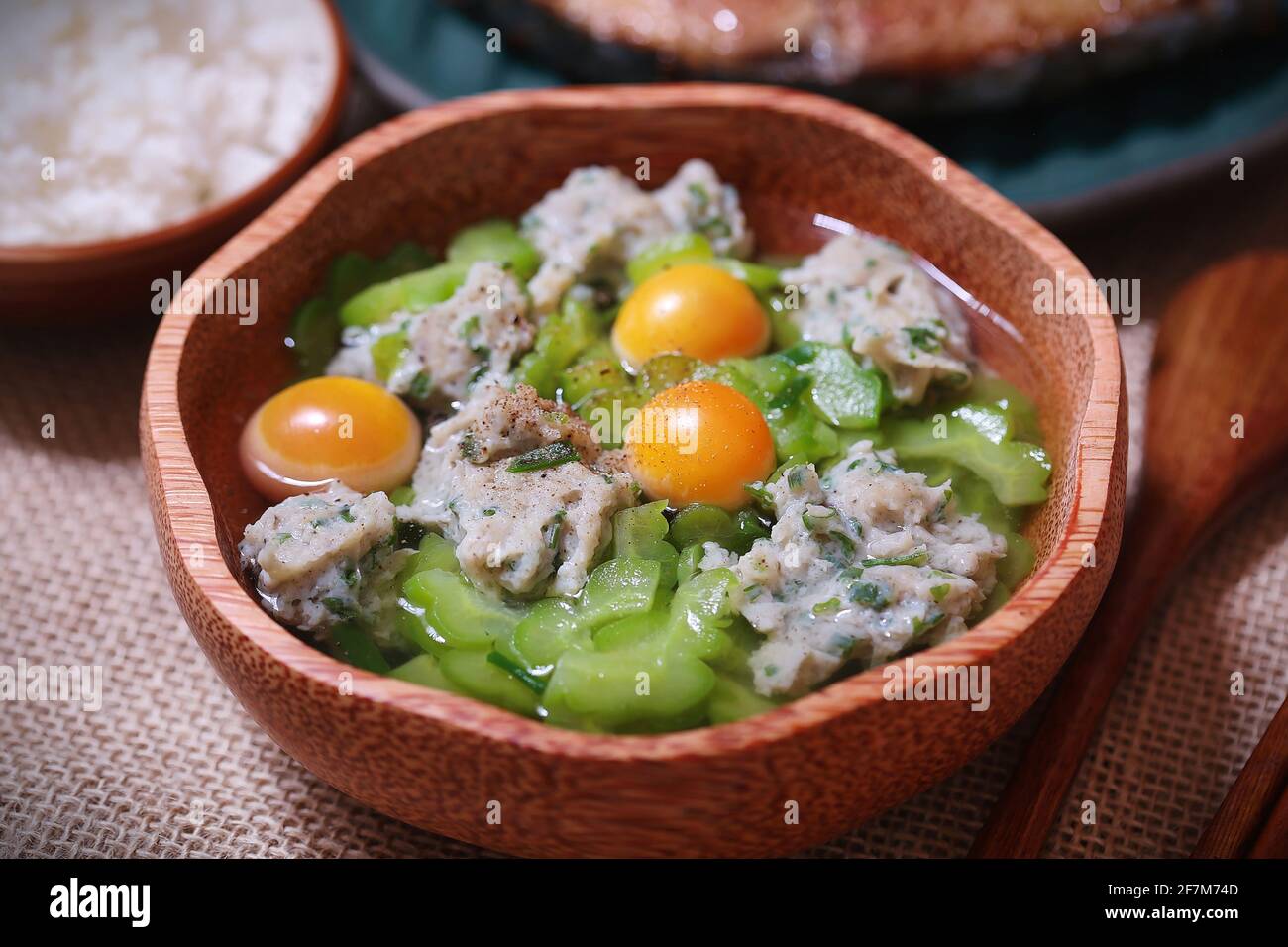 Bitter melon soup with chopped fish and egg yolks on wooden bowl Stock Photo