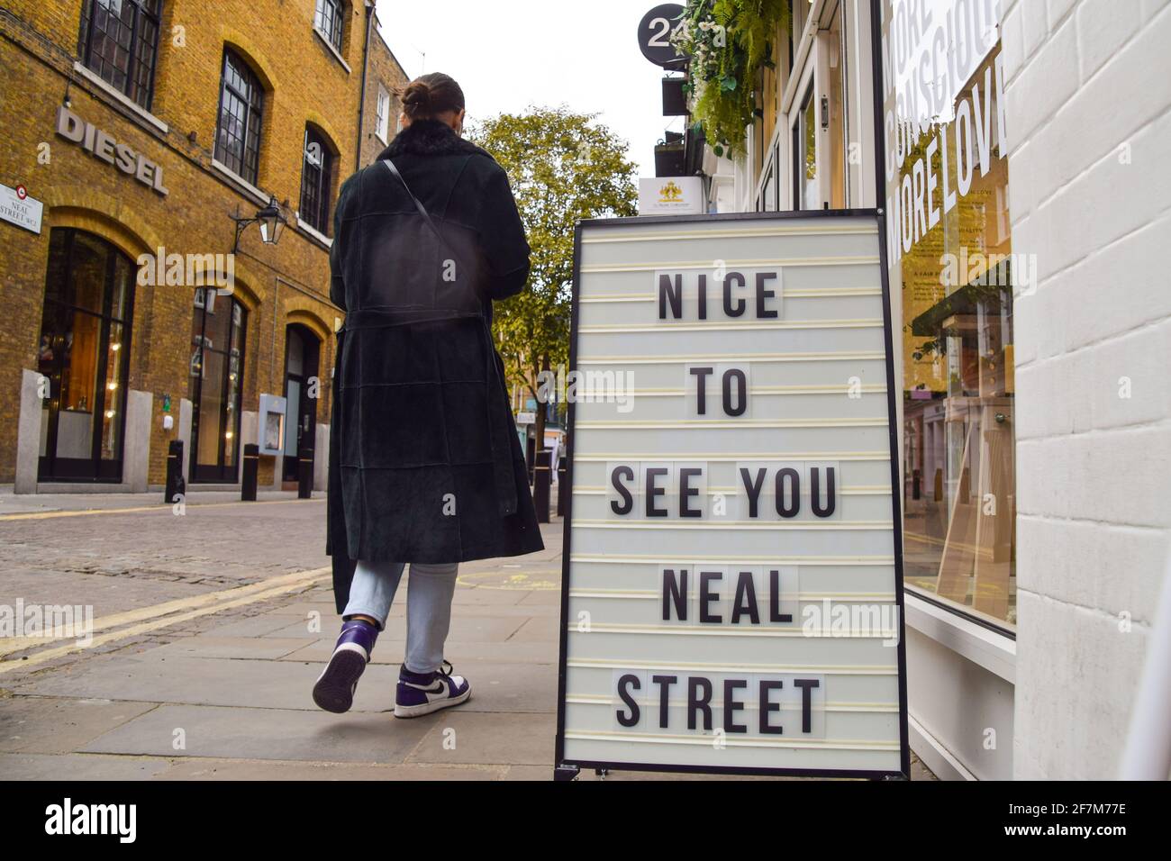 London, United Kingdom. 8th April 2021. A woman walks past a sign that reads 'Nice To See You Neal Street' in Covent Garden as shops, restaurants and other businesses prepare to reopen on 12th April. Credit: Vuk Valcic/Alamy Live News Stock Photo