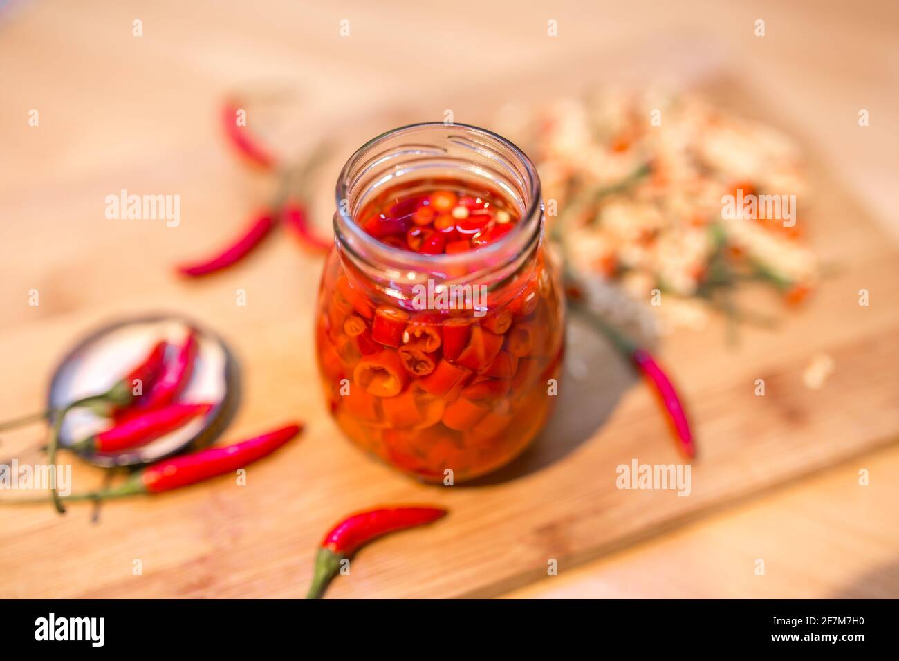 Pickle red chilli peppers with vinegar in glass jar Stock Photo