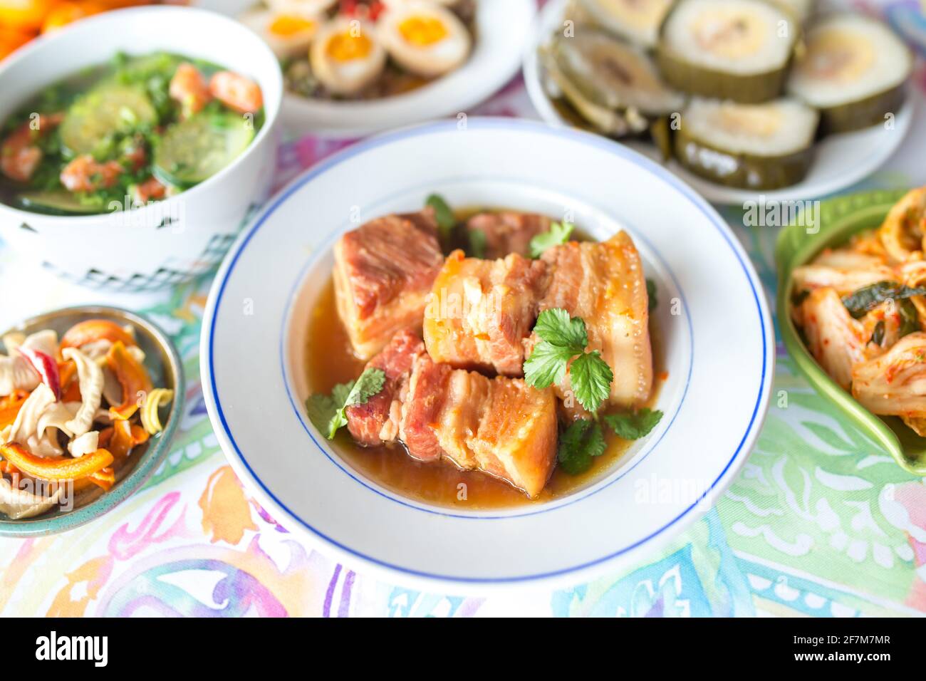 Asian family lunch set in Lunar New Year days focus on caramelized pork belly dish Stock Photo
