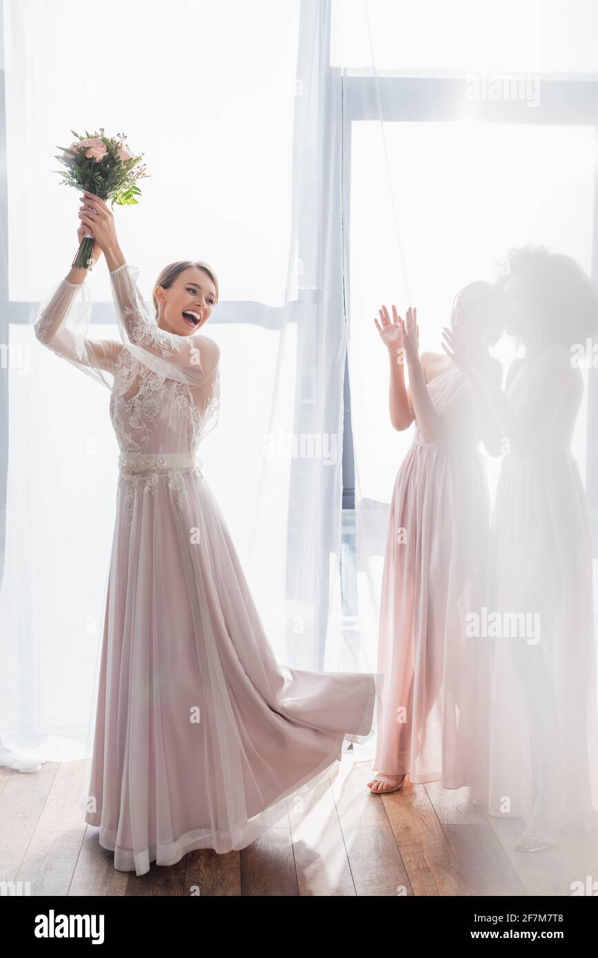 excited bride throwing wedding bouquet near bridesmaids Stock Photo Alamy