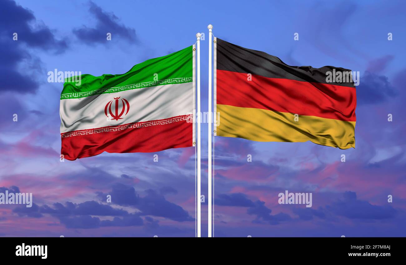 Germany and Iran flag waving in the wind against white cloudy blue sky together. Diplomacy concept, international relations Stock Photo