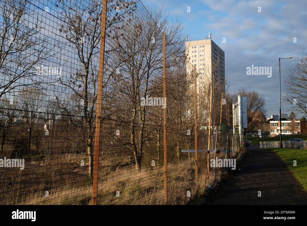 Fenced off waste ground in Balsall Heath near social housing estate high rise tower block in