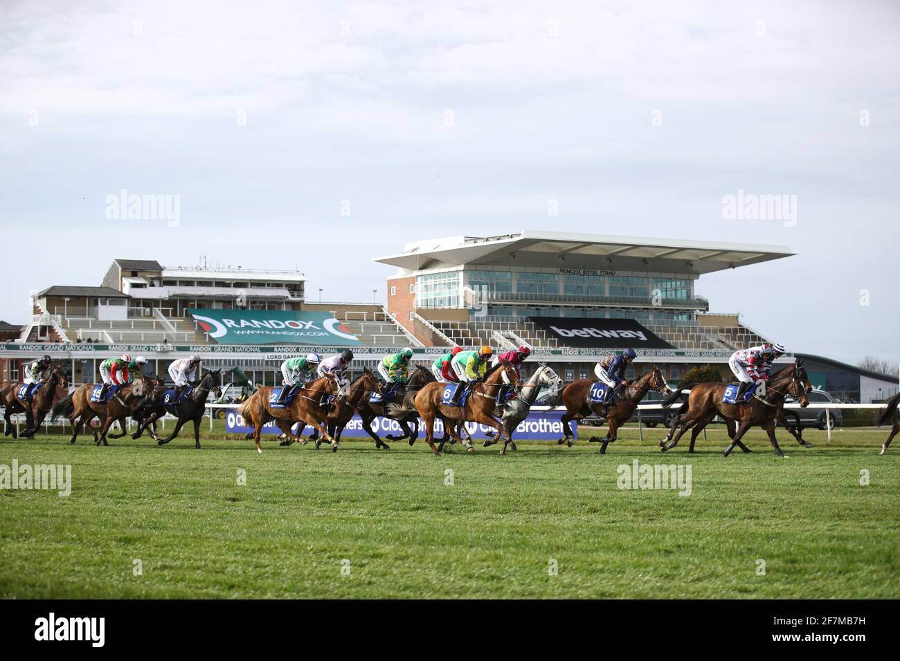 Runners and riders pass in front of the empty grandstands in the Close Brothers Red Rum Handicap Chase during the Liverpool NHS Day of the 2021 Randox Health Grand National Festival at Aintree Racecourse, Liverpool. Picture date: Thursday April 8, 2021. Stock Photo