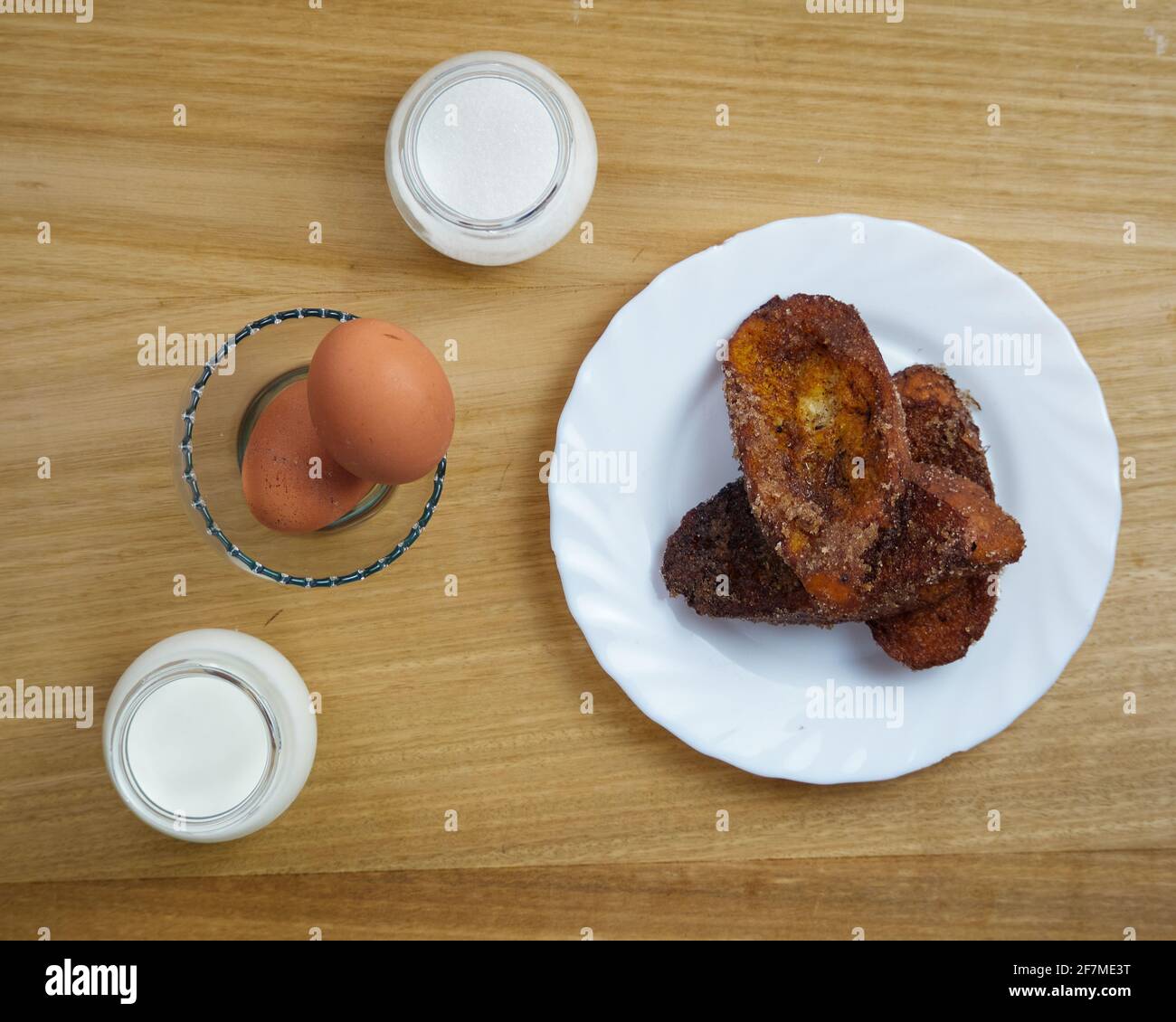 Traditional homemade Spanish Torrijas and two cinnamon sticks in a