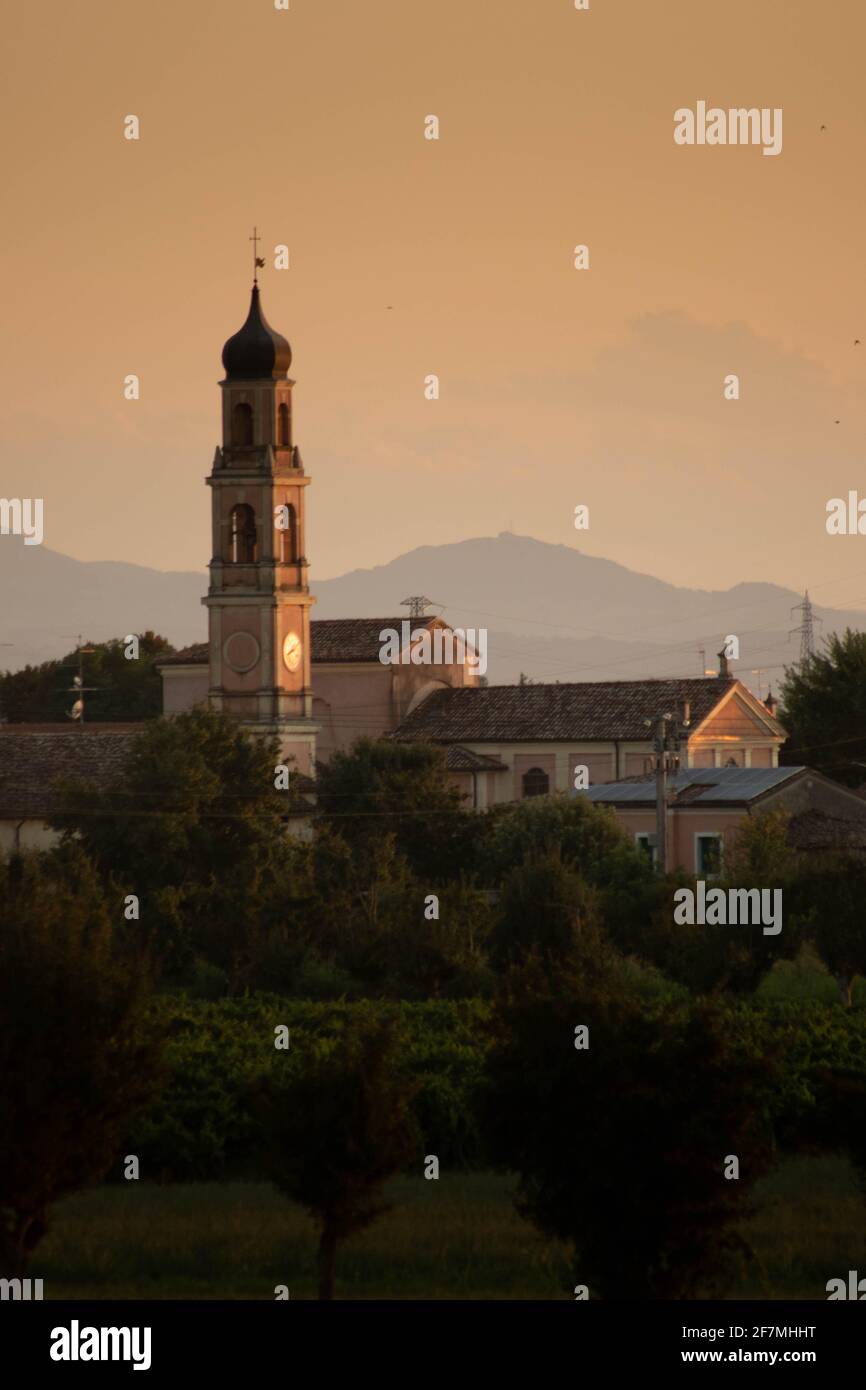 Sunset in summer with silhouette of church tower, Italy Stock Photo - Alamy