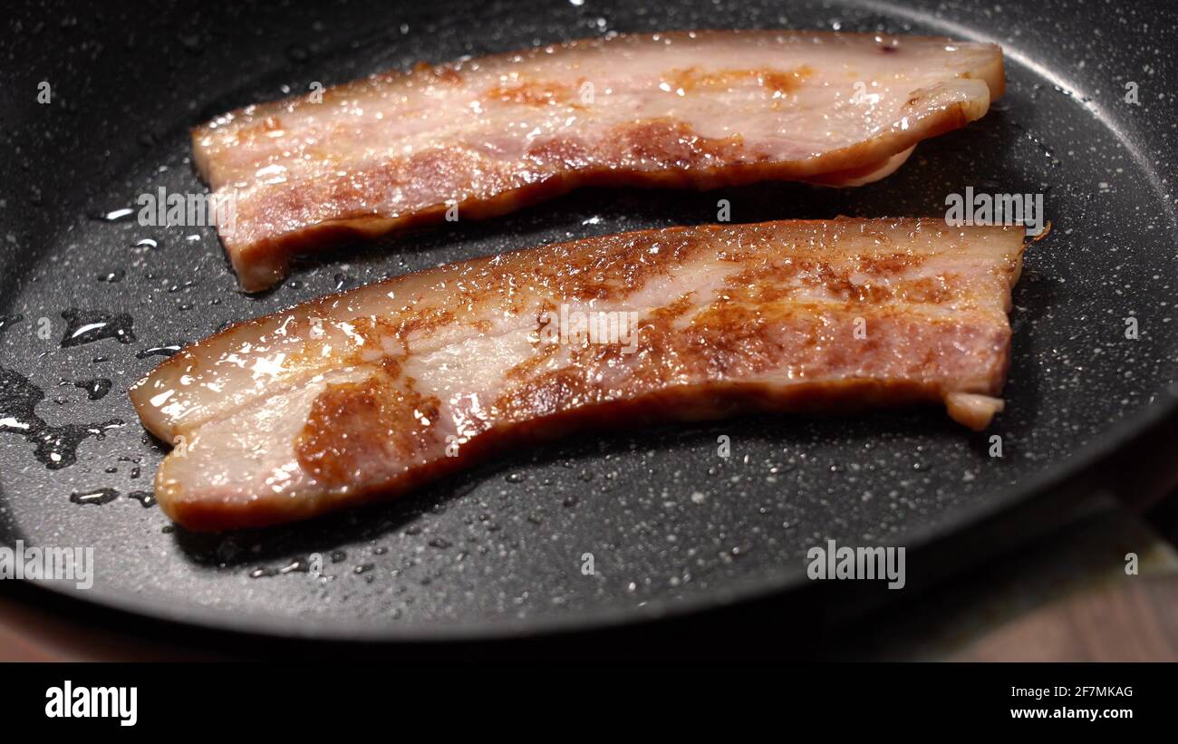 https://c8.alamy.com/comp/2F7MKAG/close-up-view-of-bacon-slices-in-frying-pan-2F7MKAG.jpg
