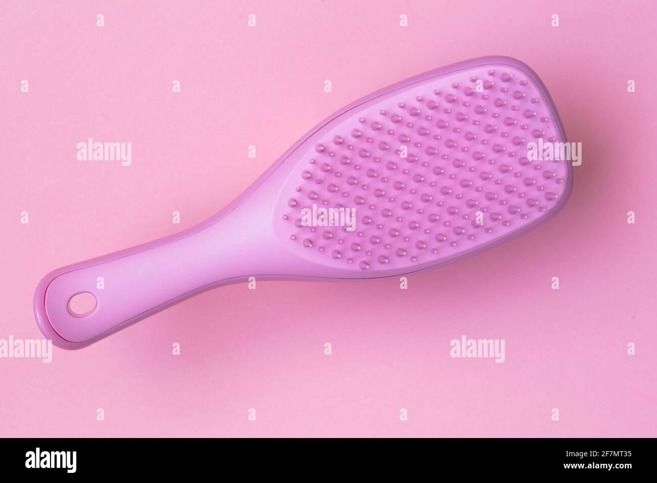 Pink hairbrush isolated on pink background Stock Photo