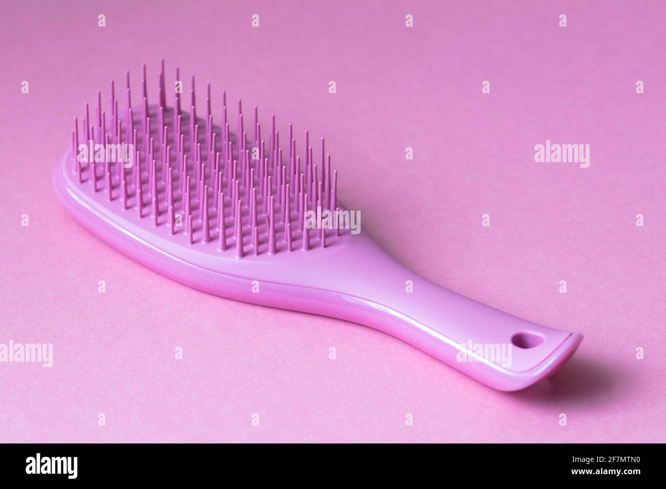 Pink hairbrush isolated on pink background Stock Photo