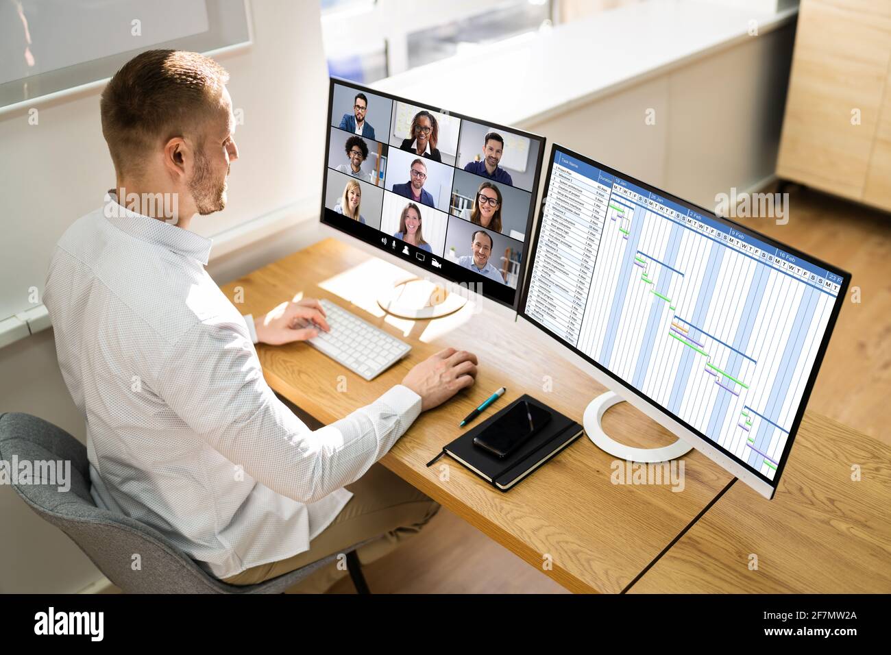 Virtual Office Conference Agenda On Multiple Desktop Screens Stock Photo