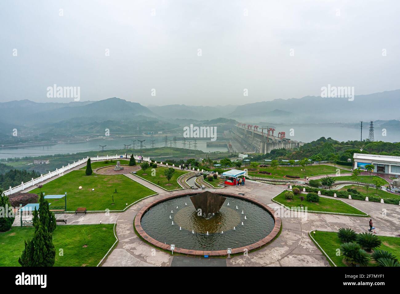 Three Gorges Dam, China - May 6, 2010: Yangtze River. Large fountain near visitor center with wide view over dam itself, river, and green hills under Stock Photo