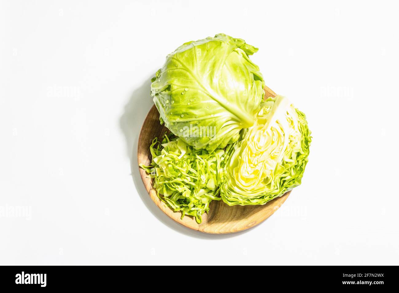 Fresh young shredded cabbage, whole head and cut piece isolated in
