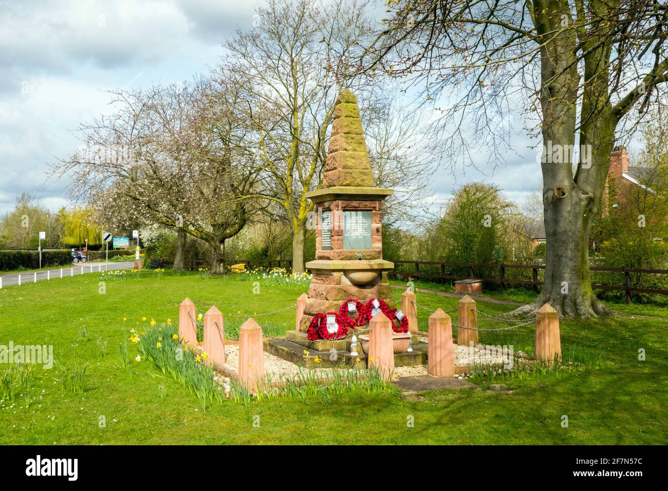 Man stood looking at the war memorial on the village green at  Bradfield Green near Crewe Cheshire Stock Photo
