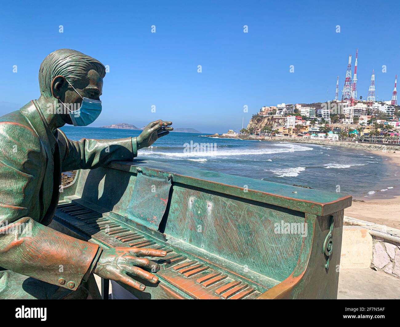 Metal pianist, statue of a pianist and his piano on the boardwalk and  beach, green figure, mouth cover, covid-19, musician in the port of  Mazatlan, Sinaloa, Mexico .... (Photo by Luis Gutierrez /