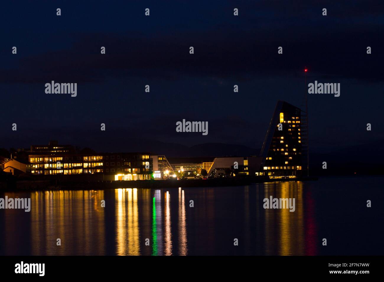 night, light reflections in water. hotel and store buildings in norway. Stock Photo