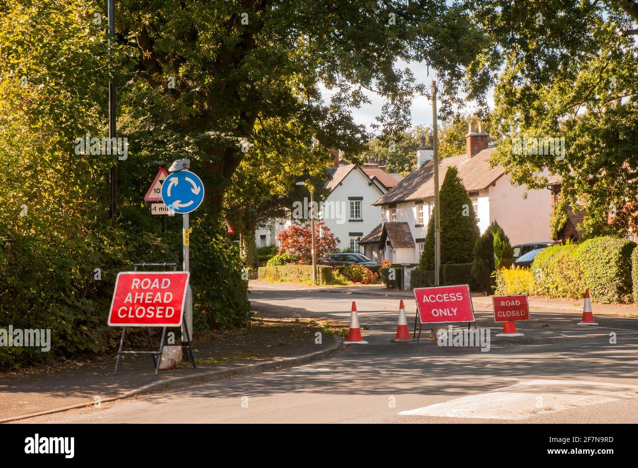 Information and warning signs of road closed and access only due to incedent on narrow country