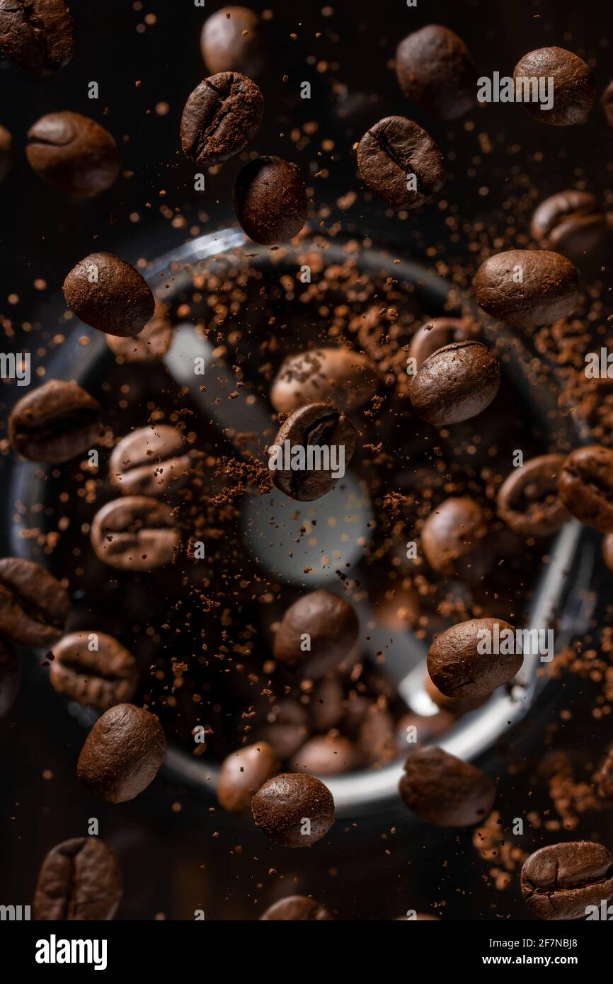 Ground coffee beans flying from a coffee grinder Stock Photo