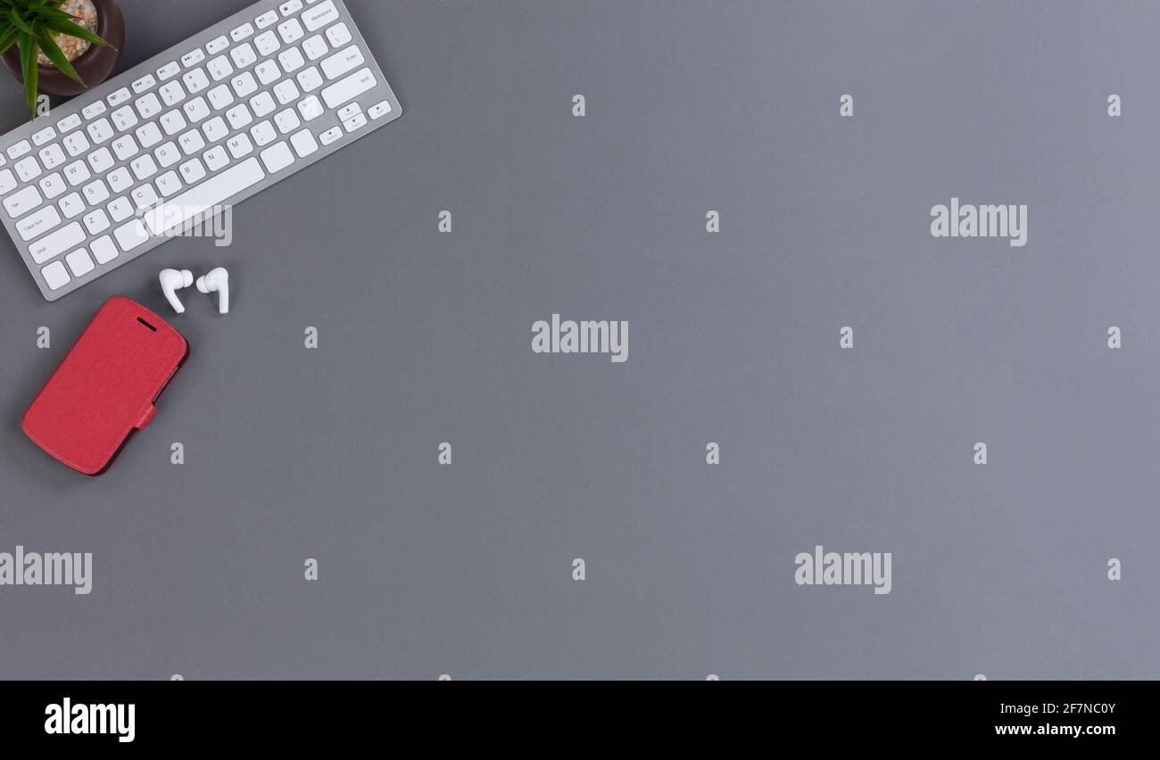 Basic wireless mobile work desktop with smartphone, computer keyboard and baby plant Stock Photo