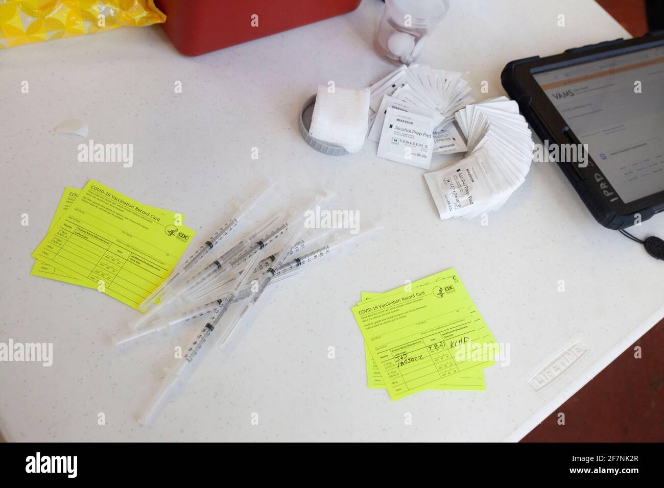 Charleston, United States. 08th Apr, 2021. Syringes lie on the table next to vaccine cards and ...