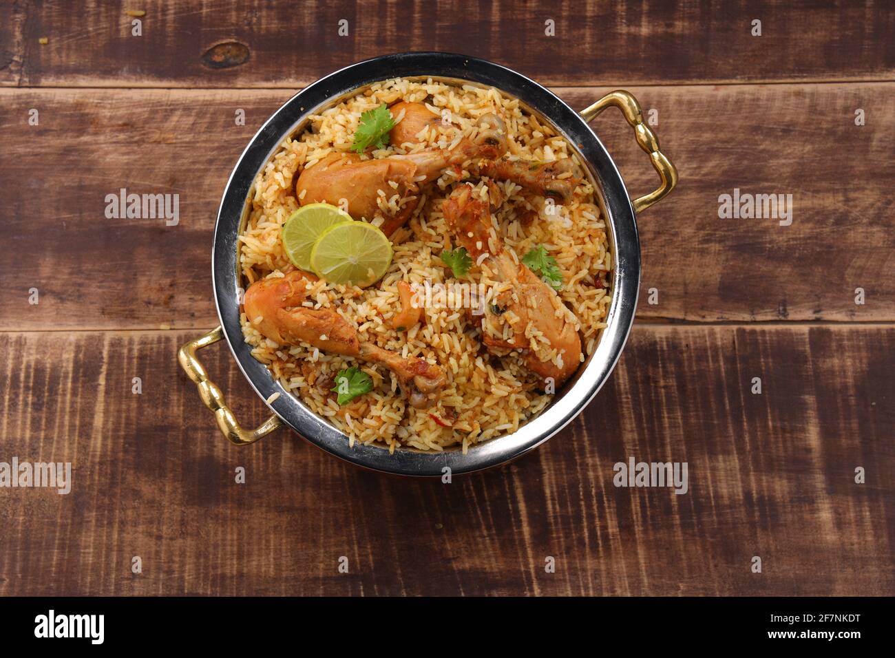 Dum chicken biriyani, close up image of Kerala-Thalassery biriyani  which is mixed with masala and yellow in colour arranged in a copper serving bowl Stock Photo