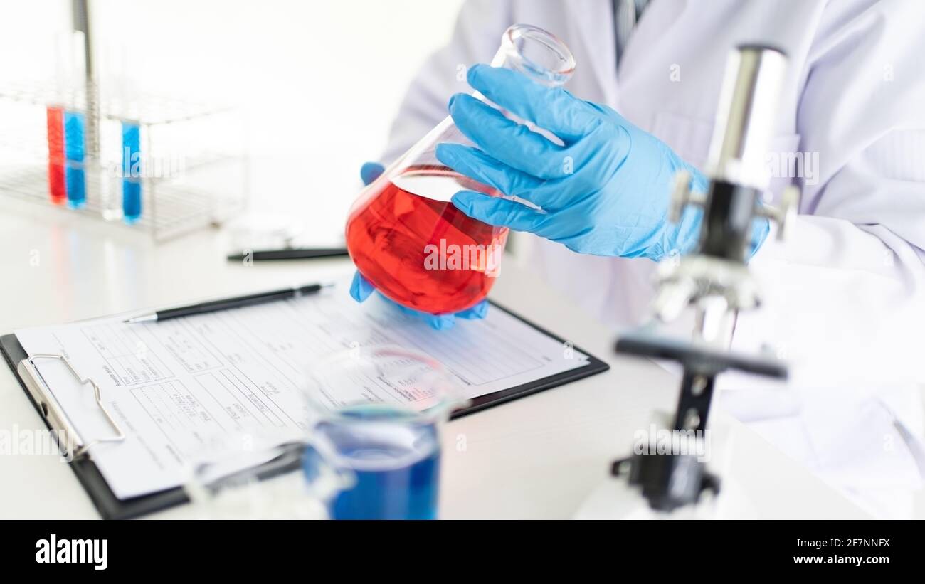 Young Asian scientist Working looking through a microscope doing ...