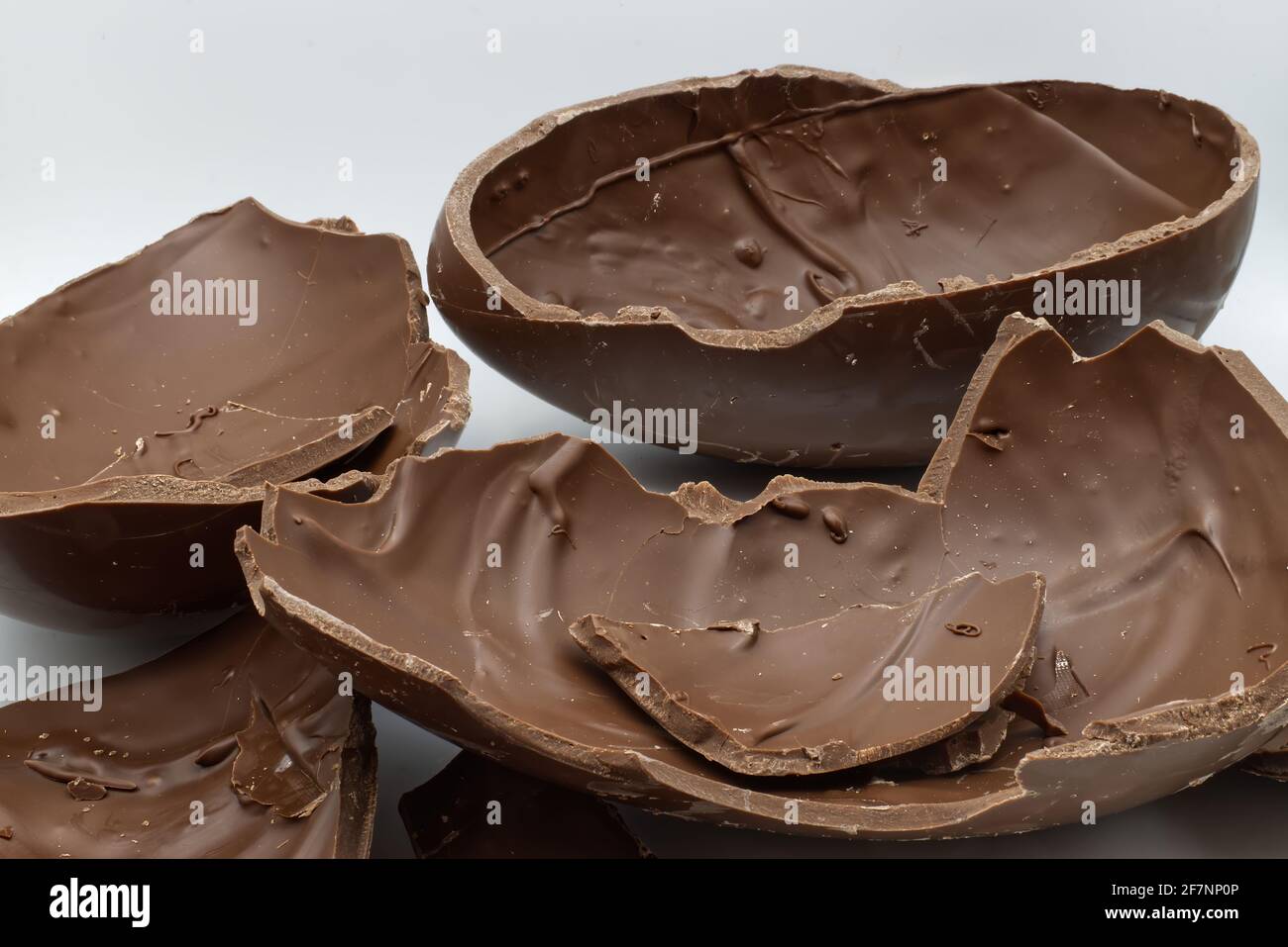 Broken chocolate Easter egg in a bowl isolated on white background Stock Photo