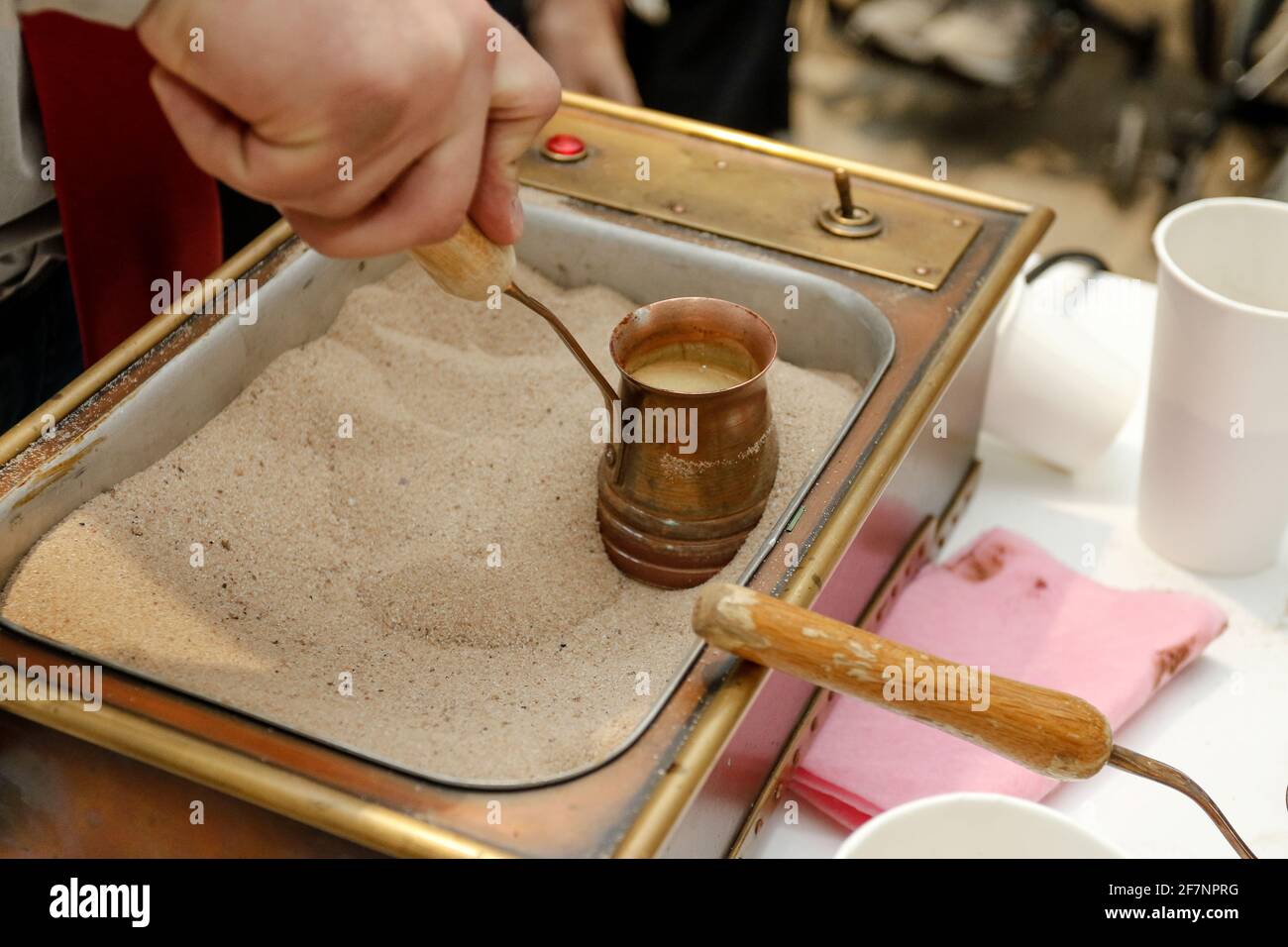 Oriental coffee or Turkish coffee. Coffee turk, hot sand, hands Stock