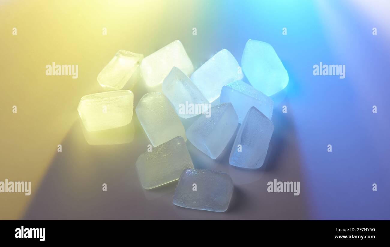 Pile of ice cubes in blue and yellow color close up view Stock Photo