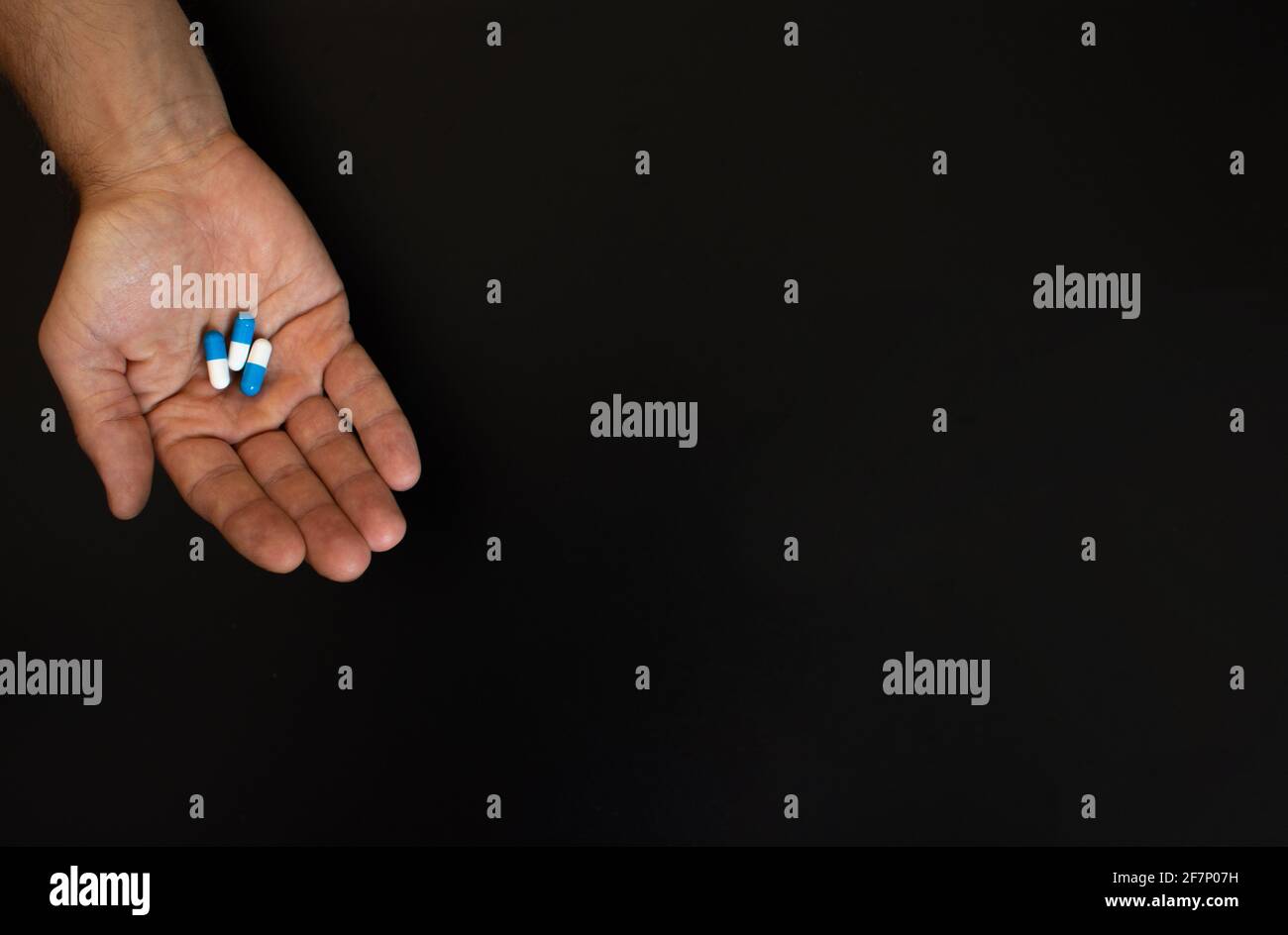 on the palm of an adult man are three tablets. Stock Photo