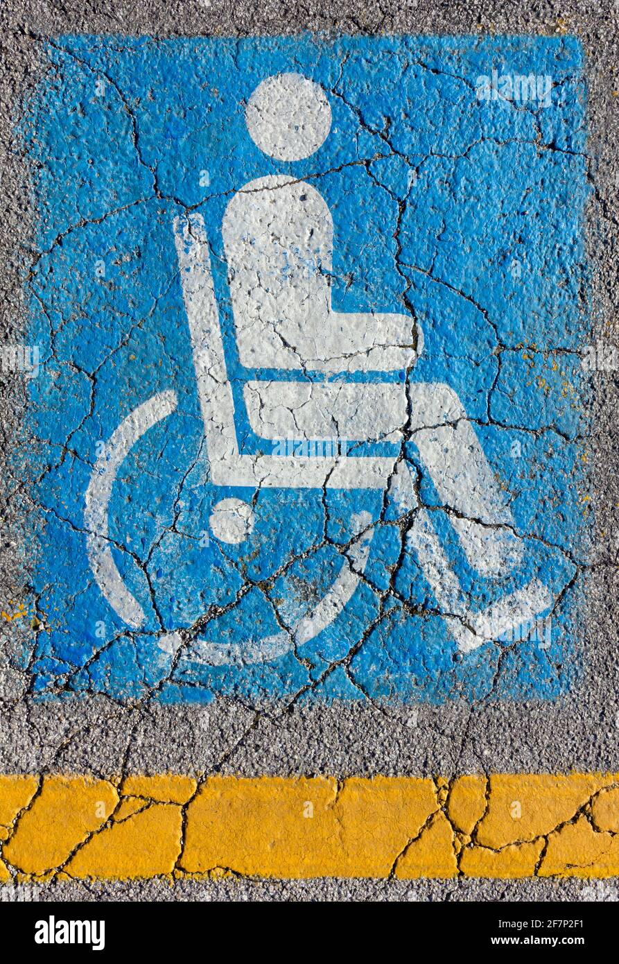 International access sign on a cracked asphalt with a yellow strip below Stock Photo
