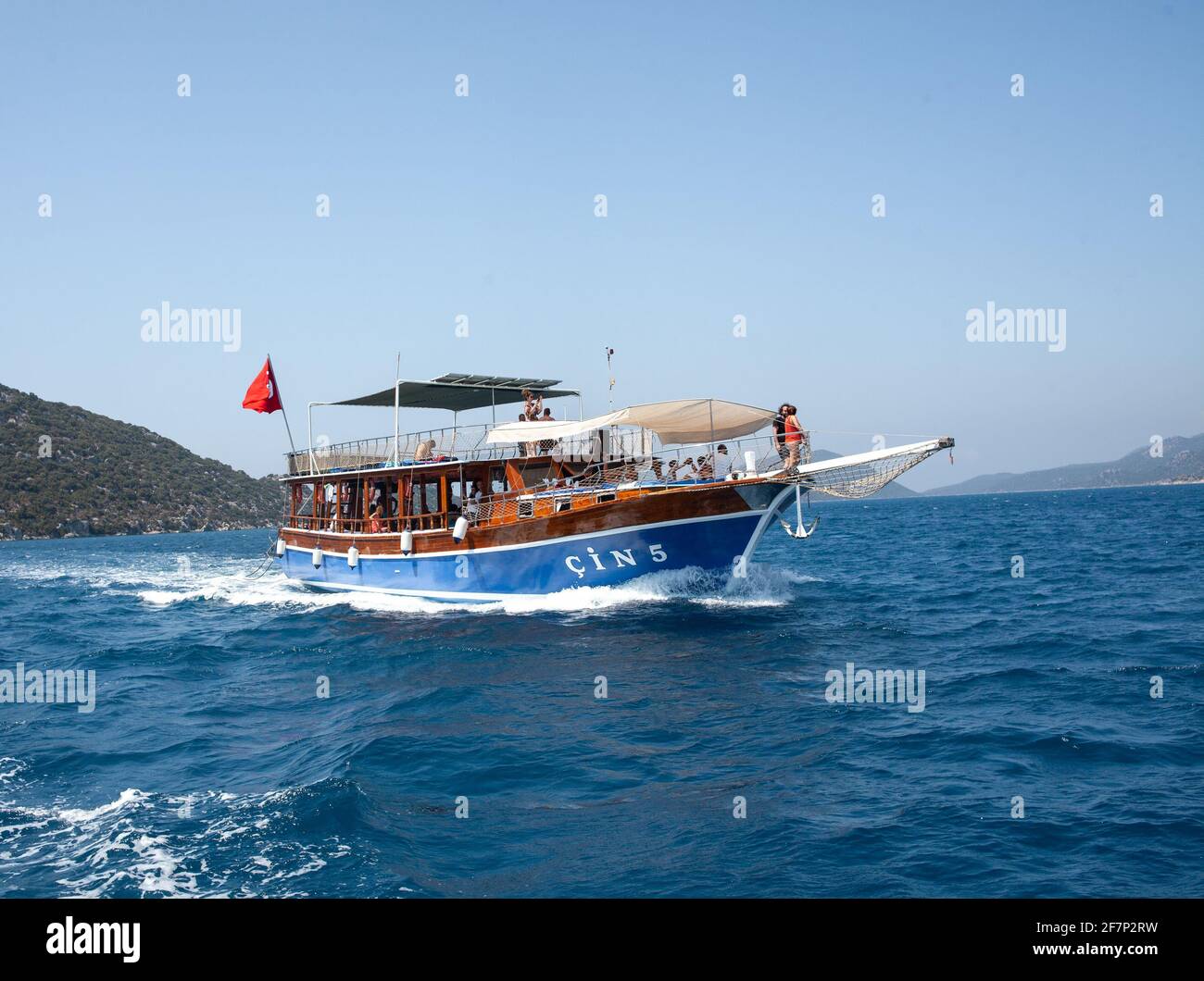 Demre, Turkey - 07.07.2020. Pleasure yacht in the sea. Tourist ship with people on board with turkish flag sails on the waves. Fast moving excursion s Stock Photo