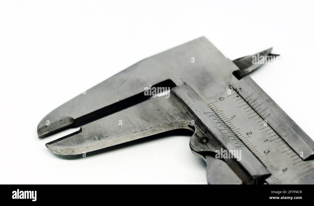 Detail view of a metallic caliper used to measure the distance between two opposite sides of an object. Engineering and construction industry. Isolate Stock Photo