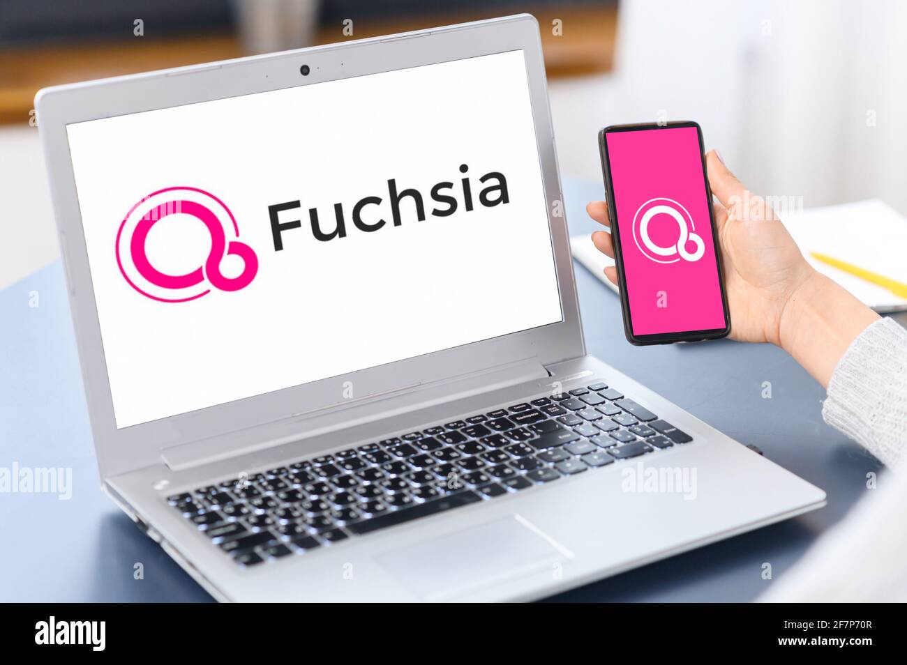 Kyiv, Ukraine - April 2, 2021: Google Fuchsia OS logos on the mobile phone screen and on the laptop display, operating system developed by Google Corporation Stock Photo