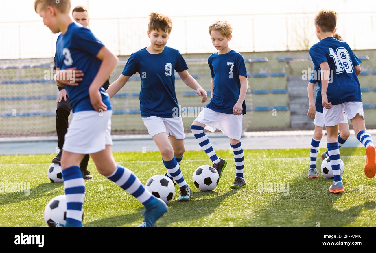 Group of School Kids on Sports Practice Class. School Physical Education Unit in Soccer Football. Outdoor Sports Training With Coach of Junior Male Te Stock Photo
