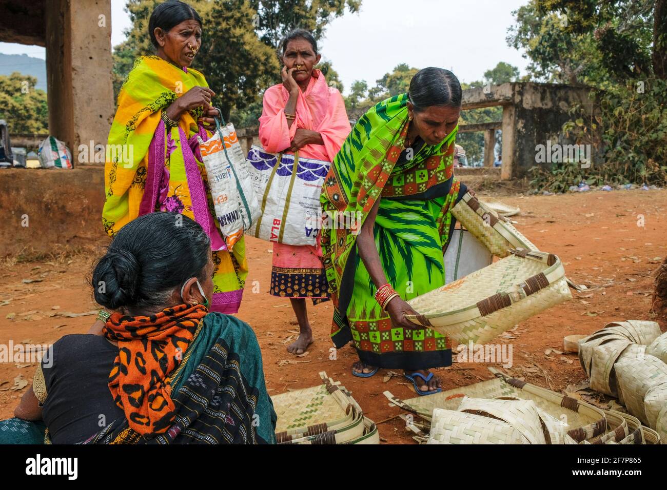 Laxmipur, India - February 2021: Adivasi women from the Kondh tribe buying cane baskets in the Laxmipur market on February 20, 2021 in Odisha, India. Stock Photo