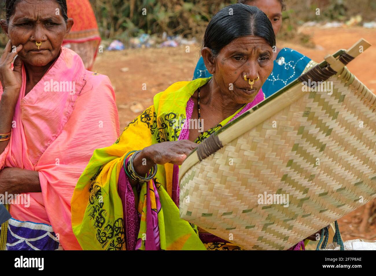 Laxmipur, India - February 2021: Adivasi women from the Kondh tribe buying cane baskets in the Laxmipur market on February 20, 2021 in Odisha, India. Stock Photo