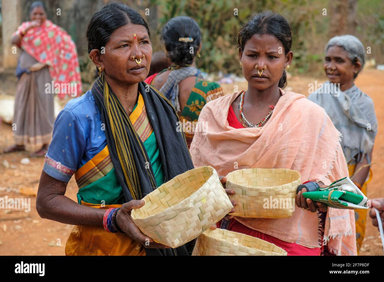 Laxmipur, India - February 2021: Adivasi women from the Kondh tribe buying cane baskets in the Laxmipur market on February 20, 2021 in Odisha, India. Stock Photo