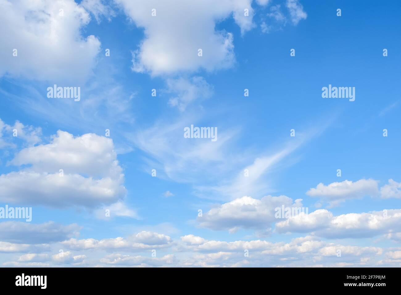 Blue sky with white fluffy clouds background Stock Photo - Alamy