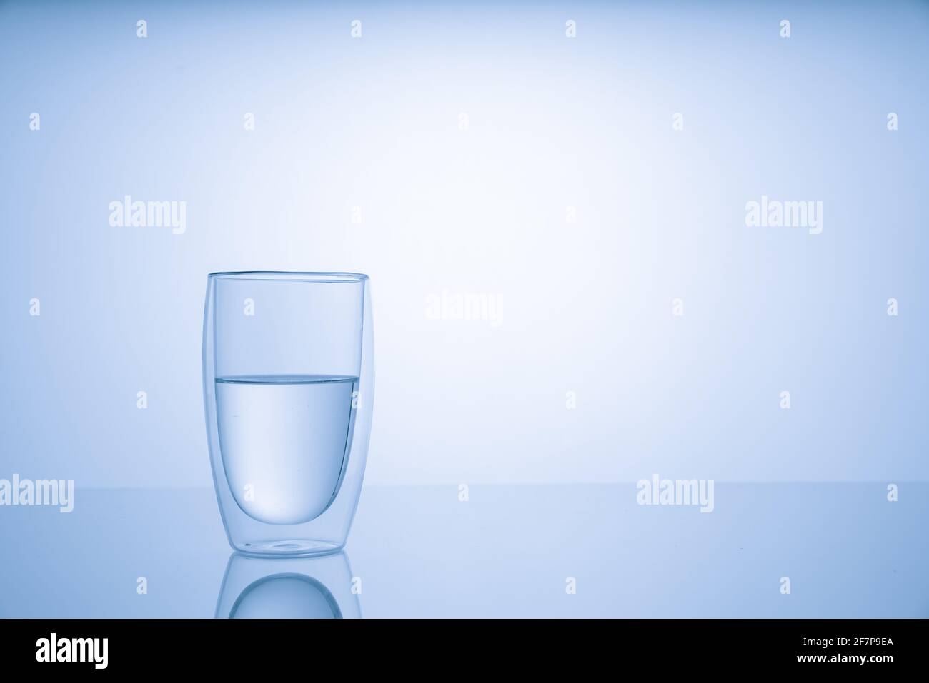 Pitcher with drinking water and a glass with a drink, blue tone Stock Photo