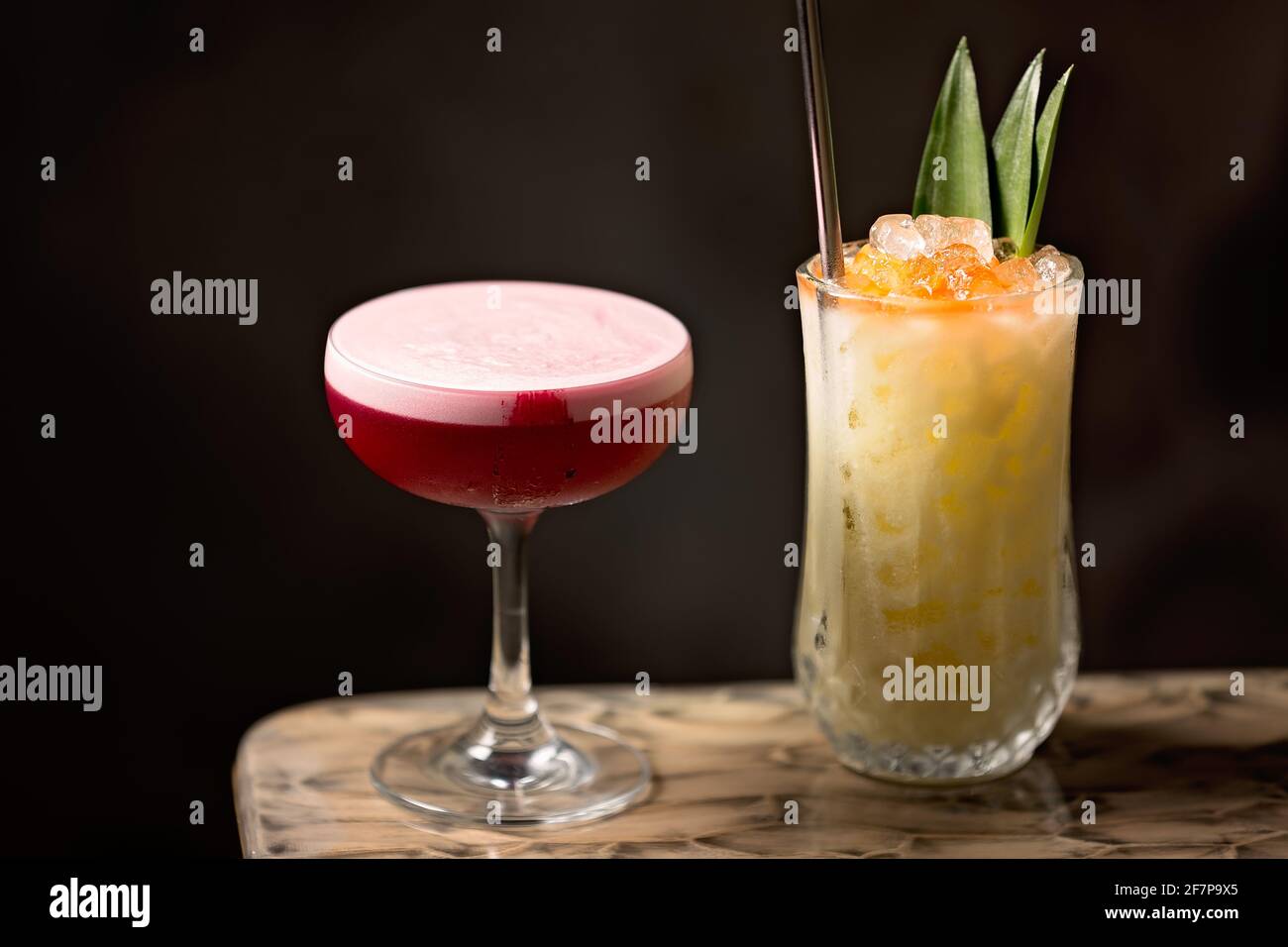 Red berries, gin, lemon, egg with short and delicious cocktail and a Rum base with pineapple and coconut long drink cocktail served over crushed ice. Stock Photo